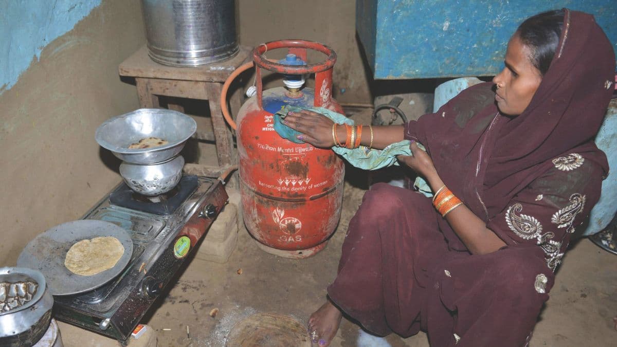 Woman using LPG cylinder for cooking under India’s household energy programme
