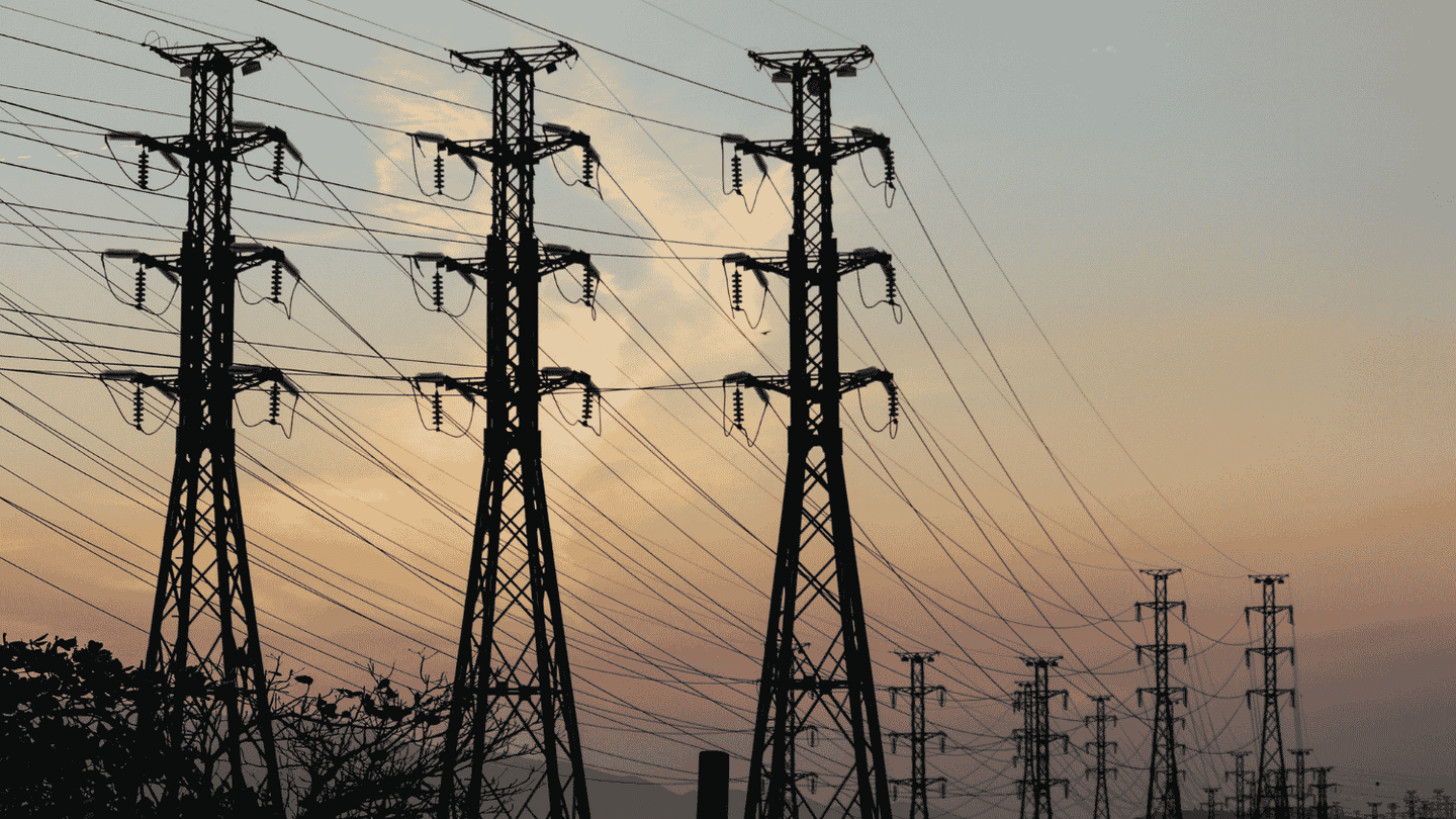 Electricity transmission towers and power lines against the evening sky.